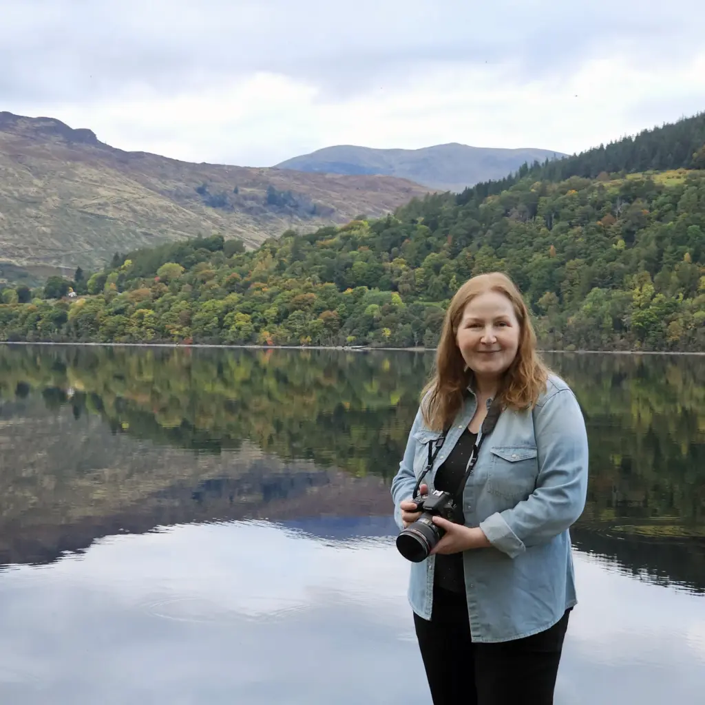 Dundee artist Carol McEwan standing next to Loch Tay