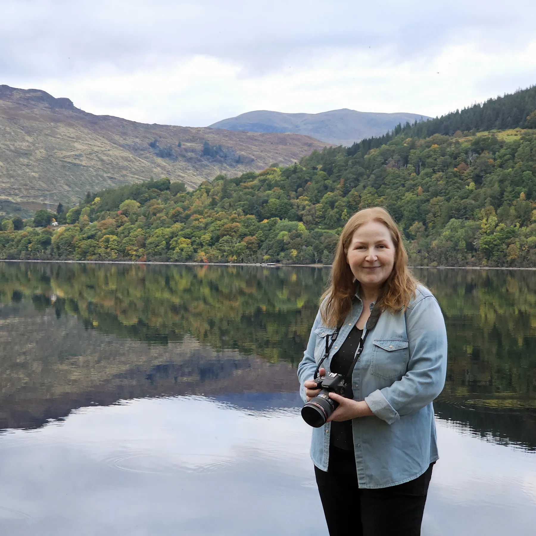 Dundee artist Carol McEwan standing next to Loch Tay